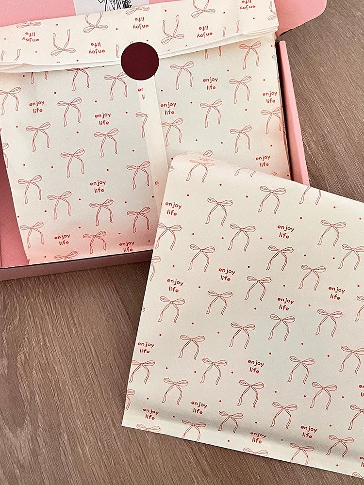 Ästhetische Geschenktüten aus Kraftpapier mit roter Schleife und dem Aufdruck „Enjoy Life“ | Flache Einkaufstüten im INS-Stil für Boutiquen