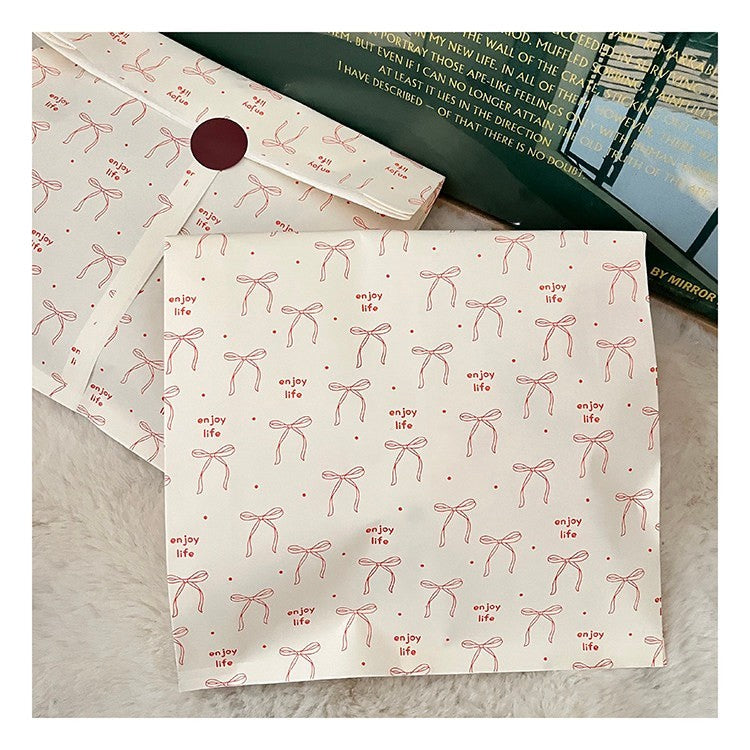 Ästhetische Geschenktüten aus Kraftpapier mit roter Schleife und dem Aufdruck „Enjoy Life“ | Flache Einkaufstüten im INS-Stil für Boutiquen